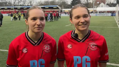 Identical twins Madison, left, and Amelia, right, stand side by side after combining to score the second and third goals in Chatham's win