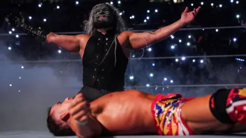 WWE wrestler Uncle Howdy in the ring as Chad Gable lies defeated during a Raw match