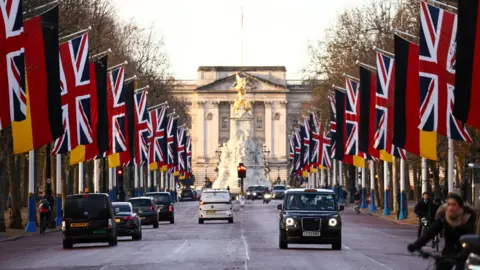 Reuters German and British flags line The Mall in London with cars driving down the road and Buckingham Palace visible in the background