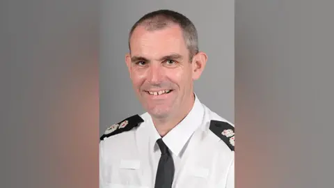 Hertfordshire Police A picture of Hertfordshire Chief Constable Charlie Hall, who has short cropped black hair. He is wearing a white police shirt with a black police tie.