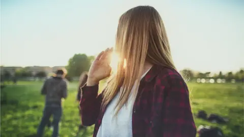 Getty Images Anonymous woman calls over friends