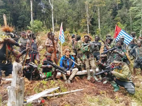 Reuters Philip Mehrtens sits among armed separatist fighters in the Indonesian region of Papua.