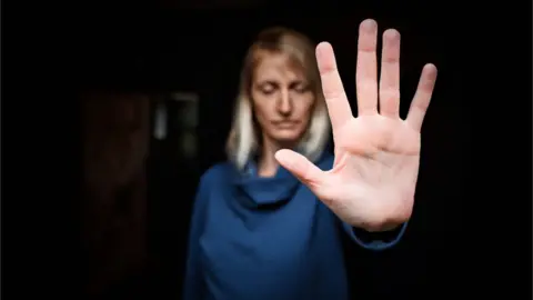 Getty Images Woman holding hand up