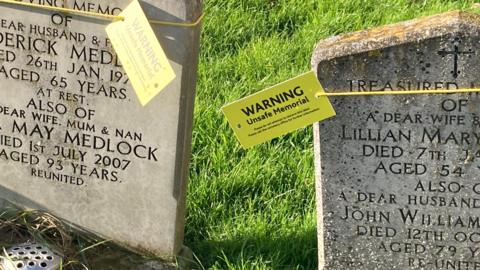 Yellow safety tags on graves