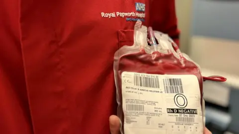 Nikki Fox/BBC Man in blood lab holding one unit of blood at Royal Papworth Hospital