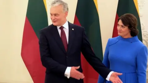 Getty Images Lithuania's President Gitanas Nauseda (3rd L) and his wife Diana Nausediene (R) before a meeting at the Presidential Palace in Vilnius, Lithuania on September 28, 2020