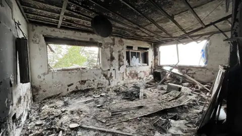 BBC Burned-out room of a building damaged by Hezbollah attack in Kibbutz Manara, northern Israel (27 November 2024)