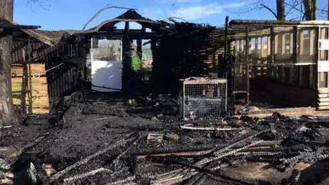 Staffordshire Fire and Rescue Firefighters hose down burnt enclosure