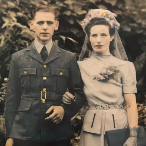 Greene family photo Francis is in his RAF uniform, whilst Hilda is wearing a belted blue dress with a short veil