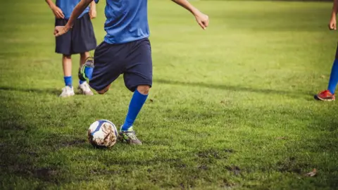 Getty Images A boy kicking a football