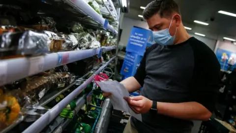 Getty Images Man wearing a mask in a shop