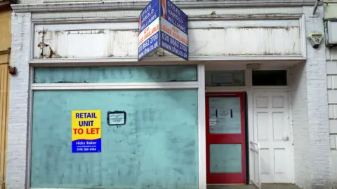 Getty Images An empty retail unit with a property agency sign in Reading, England