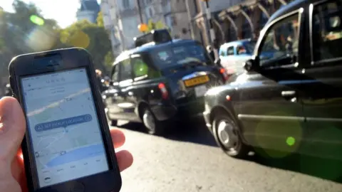 PA Man holds mobile phone by road