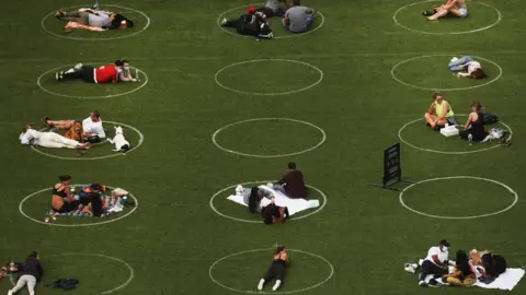 Getty Images An aerial view showing people relaxing in a park whilst staying designated white circles to ensure social distancing