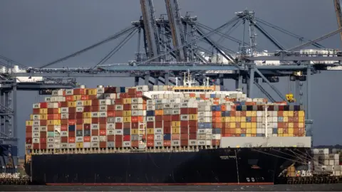 Getty Images A container ship docked at Felixstowe port last month, stacked high with containers