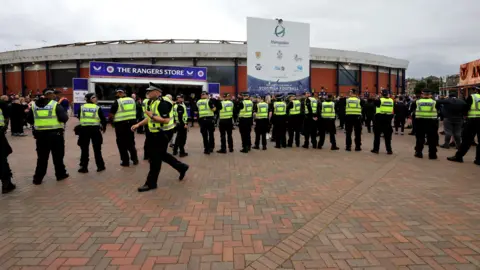 PA Images A line of police Scotland police officers wearing Hi-Vis vests outside Hampden Stadium