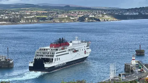 The Manxman ferry which is in the Isle of Man Steam Packet Company's colours of white, red and black, sailing out of Douglas Harbour.