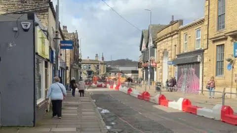 Local Democracy Reporting Service A street which is coned off with bright red and white bollards.