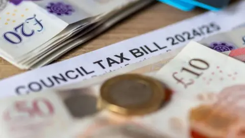 A stock image of money with a council tax bill behind it