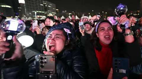 BTS fans react as they watch the comeback concert of K-pop boy group BTS