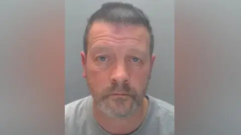 Durham Police Mugshot of Simon Vickers. He has short dark hair and a grey beard.