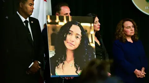 AFP via Getty Images A portrait of the late Celeste Rivas Hernandez is shown during a press briefing by Los Angeles County District Attorney Nathan J. Hochman (out of frame) on the case against singer D4vd in Los Angeles, on April 20, 2026. 