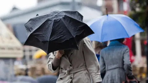 Getty Images Woman holding umbrella