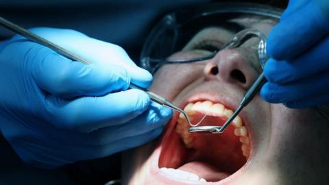 A customer is treated at a National Health Service (NHS) dental clinic 