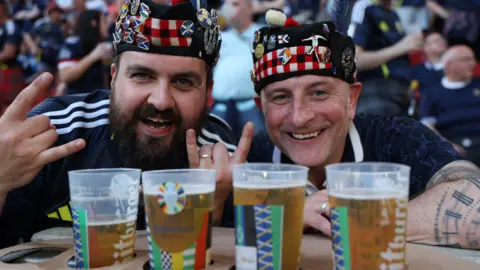 EPA Two Scottish fans with pints of beer 