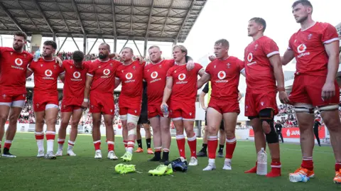 Wales players in a huddle after defeat against Japan