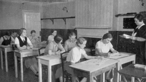 A black and white photo of students inside the Augusta Victoria College classroom. 