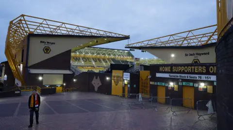 Action Images/Reuters General view of the Molineux stadium at dusk. A man in a orange and red scarf is standing in the foreground