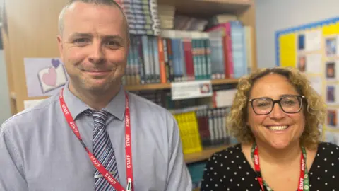 Two teachers smiling in the school library