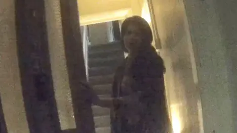 Woman opening a front door to a house