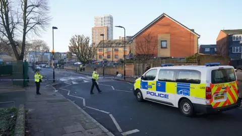 PA Media Image from 6 December of police on the scene near Vine Close, Hackney