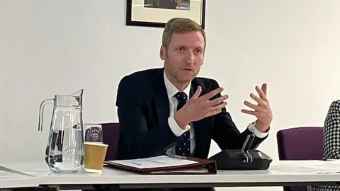 Andrew Sinclair/BBC Minister Lee Rowley speaking to councillors 