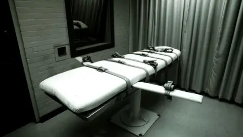 A bed with straps on it in an execution chamber