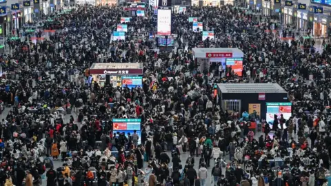 Getty Images Passengers wait for their train at Hongqiao railway station in Shanghai on January 20, 2023