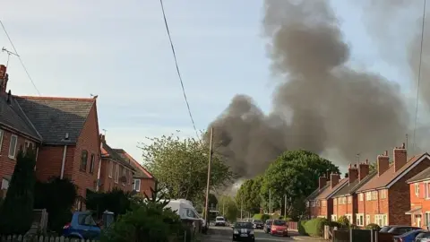 Richard Ulrich Thick black smoke can be seen rising from the scene of the fire