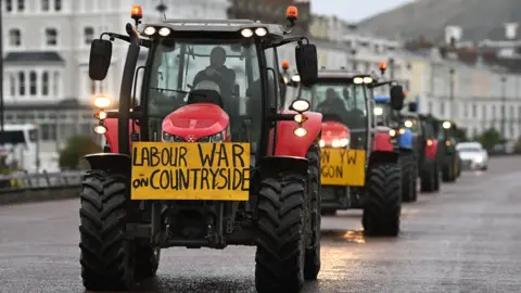 Getty Images A tractor with red hub caps and a yellow sign saying "Labour War on Countryside". 