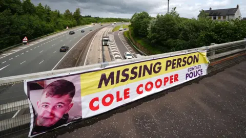 PA Media A missing person sign for Cole on a bridge over a motorway.