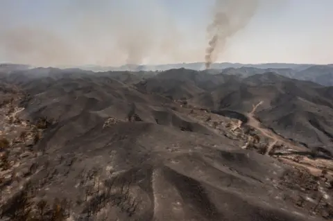 Angelos Tzortzinis / AFP An aerial view shows a burnt area after a fire near Vati, on the Greek Aegean island of Rhodes