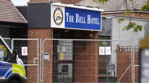 Po's Picture Pictures of Bell hotels surrounded by metal fences. Van police parked outside. 