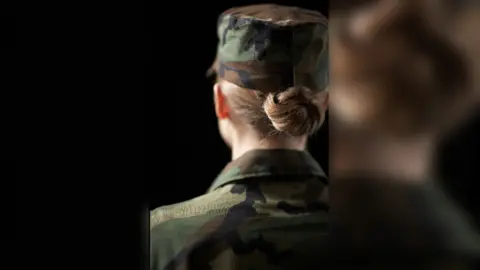 Female soldier wearing army uniform, rear view