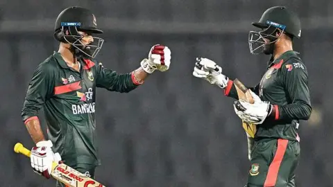 Bangladesh's Towhid Hridoy (L) and captain Mehidy Hasan Miraz (C) celebrate their team's win at the end of the second one-day international (ODI) cricket match between Bangladesh and Australia at the Sher-e-Bangla National Stadium in Dhaka 