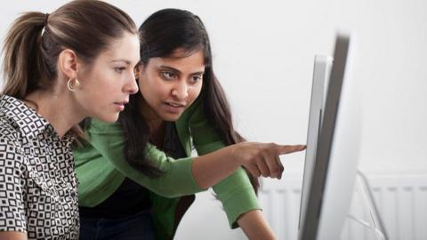 Image of two women looking at a computer screen