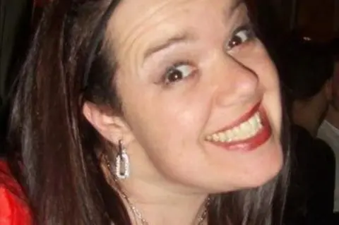 An image of Carolyn Kemp wearing a red top and smiling for the camera