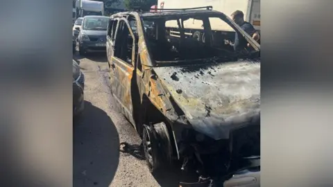 Eoghan Kelly Mobile phone image of the burnt our remains of the van