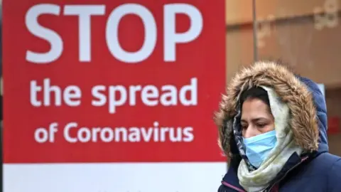 PA Media Woman wearing mask in street