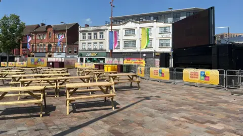 Picnic tables are visible in a square in Leicester